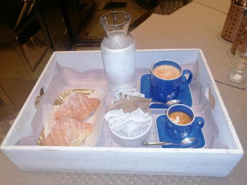 una bandeja de comida con tazas de leche y café en La casa dei colombi, en Ruvo di Puglia