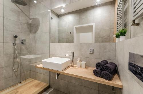 a bathroom with a sink and a shower at Apartament Majowy in Łódź