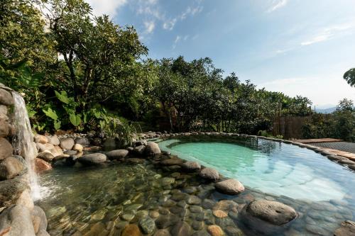 - une piscine avec une cascade et des rochers dans l'établissement Cabañas en la montaña Viga Vieja, à San Peregrino