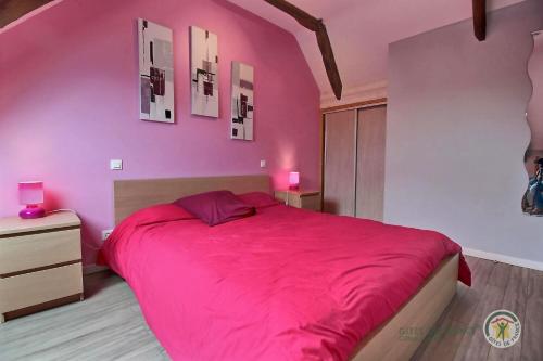 a pink bedroom with a large bed with pink sheets at Le fournil in Camlez