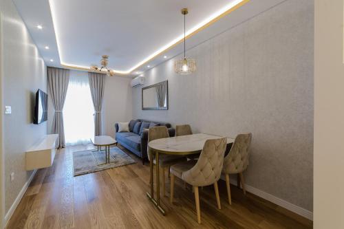 een woonkamer met een tafel en een bank bij Apartments Centrale 28 in Podgorica