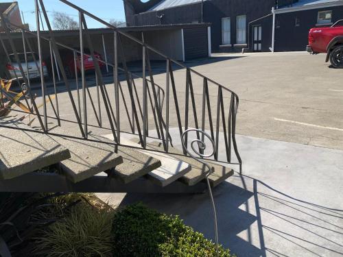 a metal railing on a staircase in a parking lot at Temuka Motel in Temuka