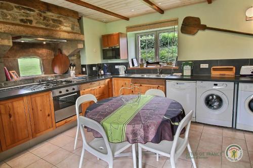 a kitchen with a table and a stove top oven at Le fournil in Camlez
