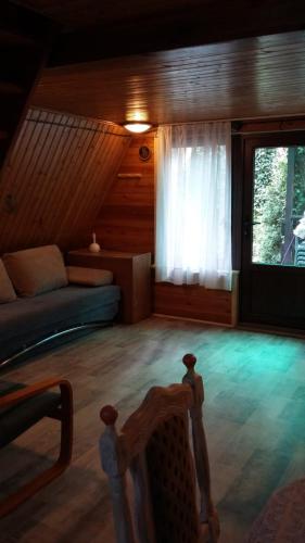uma sala de estar com um sofá e uma janela em Domek pod świerkami 2 em Skorzęcin