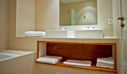 y baño con 2 lavabos, espejo y toallas. en Hotel Rural Salvatierra, en Salvatierra de Tormes