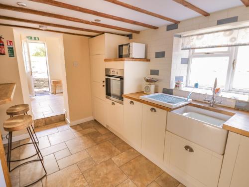 a kitchen with a sink and a stove at Rainforest Cottage in Cinderford