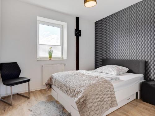 a bedroom with a bed and a chair and a window at Spacious Family Haven in Kröpelin in Kröpelin