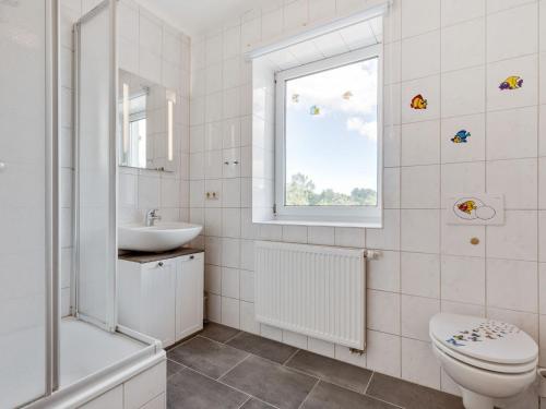 a bathroom with a toilet sink and a window at Spacious Family Haven in Kröpelin in Kröpelin