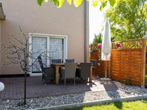 a patio with a table and chairs and an umbrella at Spacious Family Haven in Kröpelin in Kröpelin