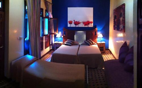 a bedroom with a bed in a room with blue walls at Riad Assilah in Asilah