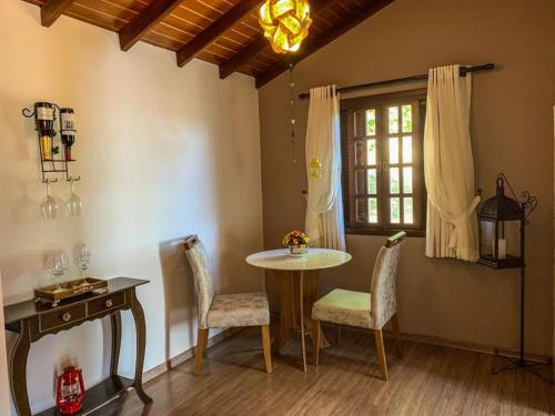 uma sala de jantar com uma mesa e cadeiras e uma janela em Pousada Colina das Andorinhas em Gonçalves