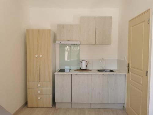 a kitchen with wooden cabinets and a counter top at STUDIO PRIVATIF CLIMATISÉ , TERRASSE ET PiSCINE in Pernes-les-Fontaines