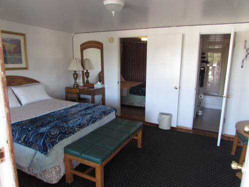 a bedroom with a bed and a bench in a room at Mel Haven Motel in Colorado Springs