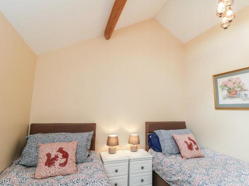 two beds in a attic bedroom with two lamps at The Stables in Great Driffield