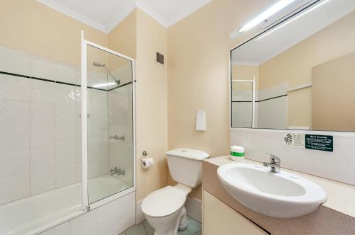 a bathroom with a sink and a toilet and a shower at Tropical Queenslander in Cairns