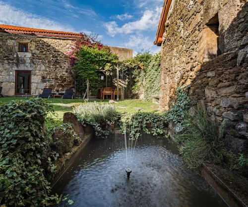 a pond in the courtyard of a stone building at Pazo de Lemaio in Laracha