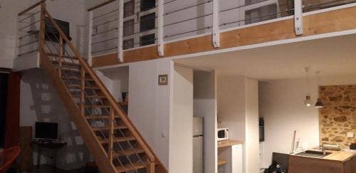 a room with a staircase leading up to a loft at La grange du moulin in Saint-Christophe