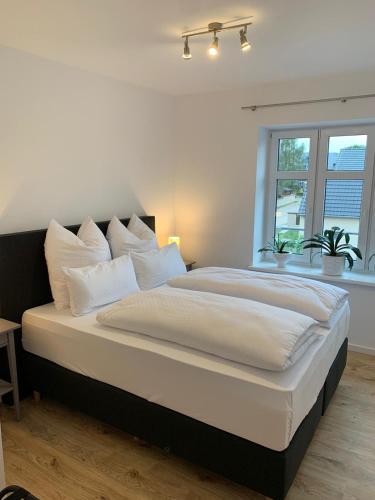 a bedroom with a large bed with white pillows at Landgasthof Alter Krug Potsdam OT Marquardt in Potsdam