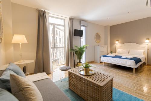 sala de estar con cama y sofá en Wonder Apartments, en Madrid