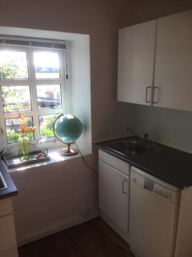 uma pequena cozinha com um lavatório e uma janela em Holiday Home centrum Lemvig em Lemvig