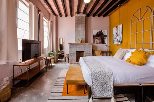 a bedroom with a large bed and a fireplace at Selina San Miguel de Allende in San Miguel de Allende