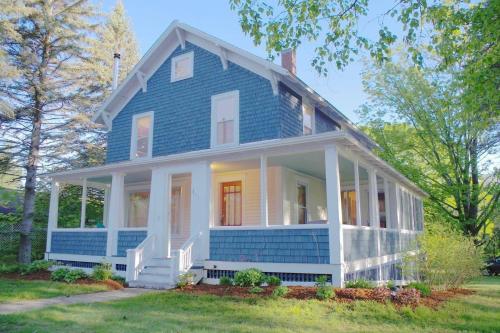 a blue house with a white porch at The Craftsman Farmhouse with Modern Flair in Bethlehem