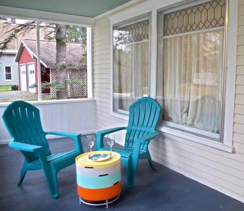 two chairs and a table on a porch at The Craftsman Farmhouse with Modern Flair in Bethlehem