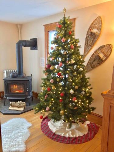 a christmas tree in a living room with a fireplace at The Craftsman Farmhouse with Modern Flair in Bethlehem