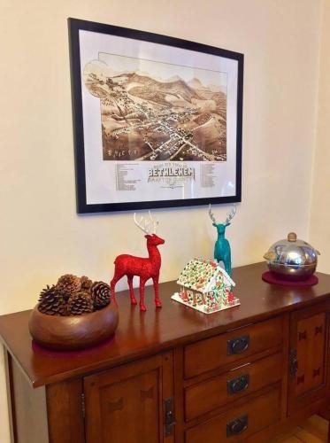a wooden dresser with a picture and a deer on it at The Craftsman Farmhouse with Modern Flair in Bethlehem