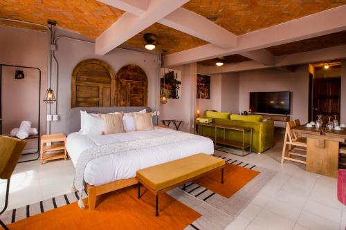 
a living room with a bed, chair, and table at Selina San Miguel de Allende in San Miguel de Allende

