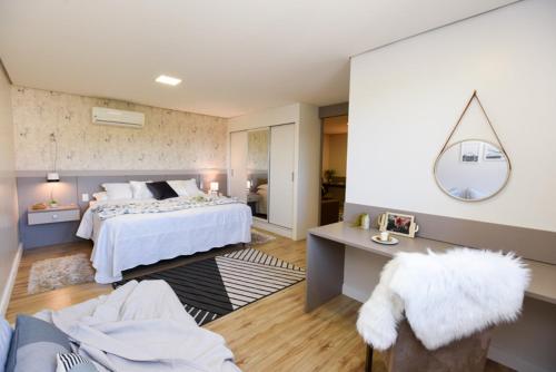 um quarto com uma cama e uma escrivaninha com espelho em APTO DE LUXO, 3 SUITES, 1 MASTER E 2 AMERICANAS, CENTRO 300mtos RUA COBERTA, GRAMADO em Gramado