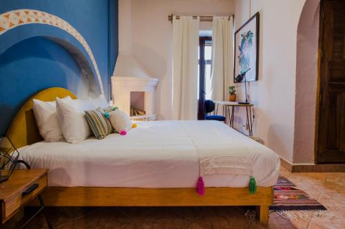 a bedroom with a large white bed with a blue wall at Selina San Miguel de Allende in San Miguel de Allende