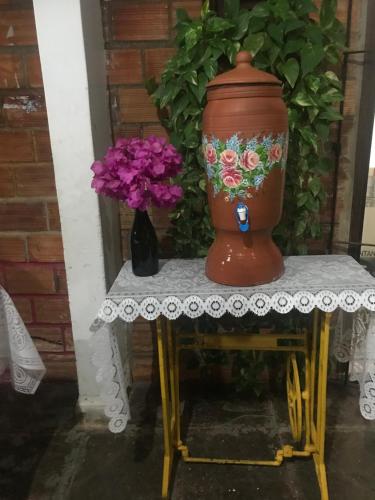 a large vase sitting on a table with flowers at Pousada Santa Bárbara in Maruda