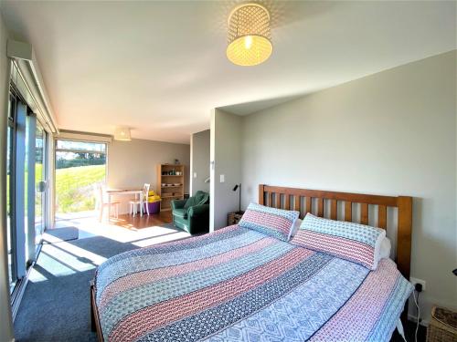 a bedroom with a bed and a large window at Addictive View - Lakeside Studio in Rotorua
