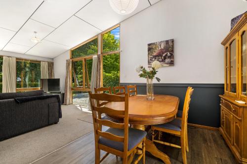 a living room with a table and chairs and a couch at Merioneth Retreat - Arrowtown Holiday Home in Arrowtown
