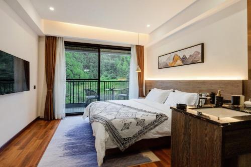 a bedroom with a bed and a tub and a balcony at Whispering Mountains Boutique Hotel in Zhangjiajie