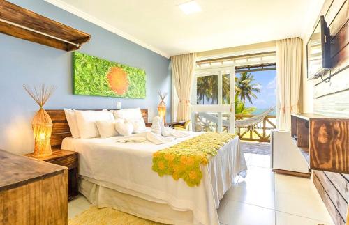 a bedroom with a bed and a view of the ocean at Pousada Marceneiro in São Miguel dos Milagres