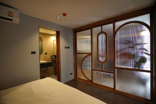 a bedroom with a bed and a window and a bathroom at Seamira House Huahin in Hua Hin