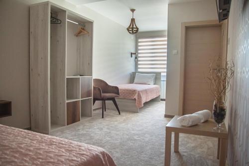 sypialnia z 2 łóżkami, biurkiem i krzesłem w obiekcie Mehana apartmani w mieście Leskovac