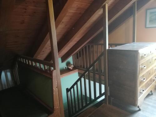 an attic room with a staircase and a wooden ceiling at Rifugio Monte Zeus in Baceno