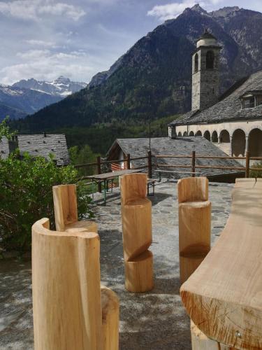 a group of wooden tables and benches in front of a building at Rifugio Monte Zeus in Baceno