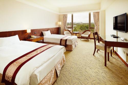 a hotel room with two beds and a desk and a television at Aspire Resort in Longtan