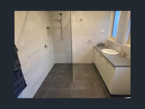 a bathroom with a shower and a sink at Holiday house among native trees overlooking wetlands in Ocean Grove