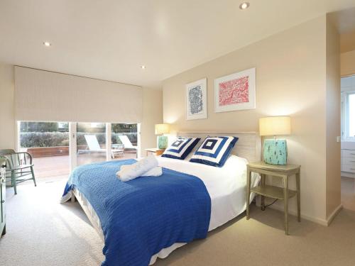 1 dormitorio con 1 cama con almohadas azules y blancas en The Beach House, en Sorrento