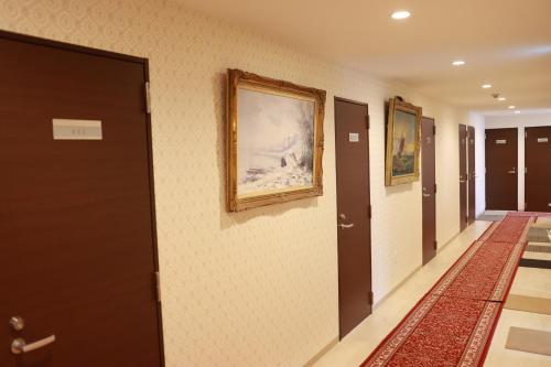 a hallway with two doors and a painting on the wall at Tokyo Guest House 2020 in Tokyo