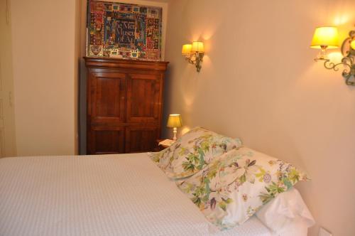 a bedroom with a bed and a wooden cabinet at Le Jas Du Colombier in Moustiers-Sainte-Marie