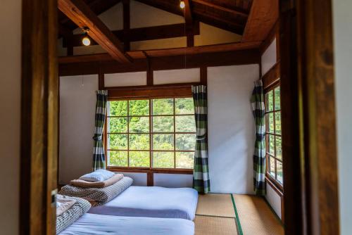 two beds in a room with a window at Momonga Village in Miyoshi