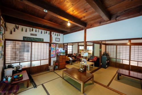 a living room with wooden ceilings and a table at Momonga Village in Miyoshi