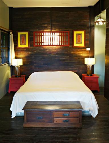 a bedroom with a bed and two night stands with two lamps at The Riverside Guest House in Lampang