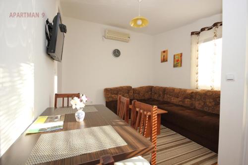 a living room with a table and a couch at Apartments Kojic in Bar